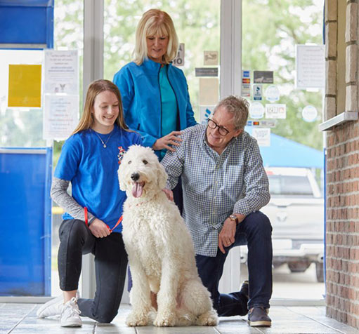 Staff members posing with a dog
