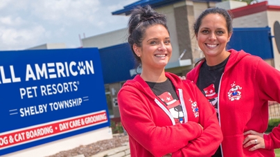 Two women stand outside of an All American Pet Resorts