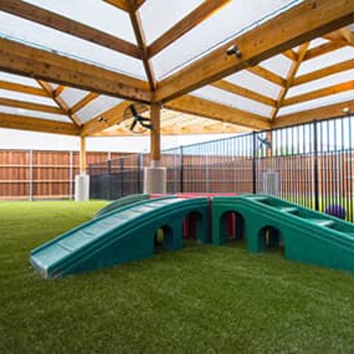 A play staircase outside in an enclosed play area