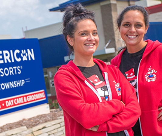 Two AAPR employees stand outside the sign for the Shelby Township location