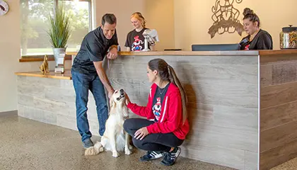 Pet parent at front desk dropping off dog at local All American Pet Resorts Lakeshore