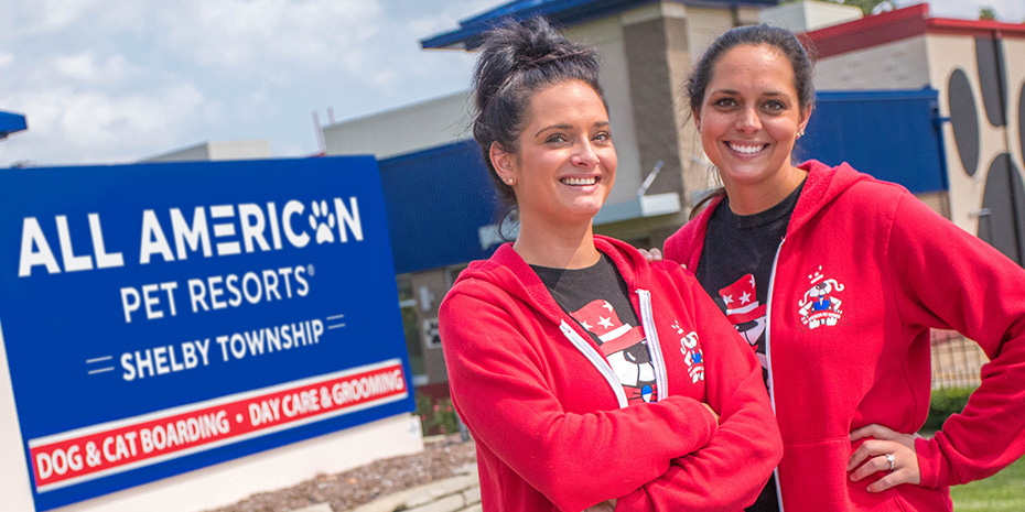 Two women stand outside of an All American Pet Resorts location