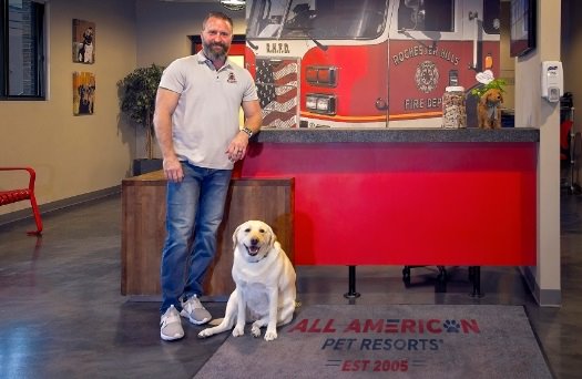 Chris smiles next to a dog at AAPR Rochester Hills